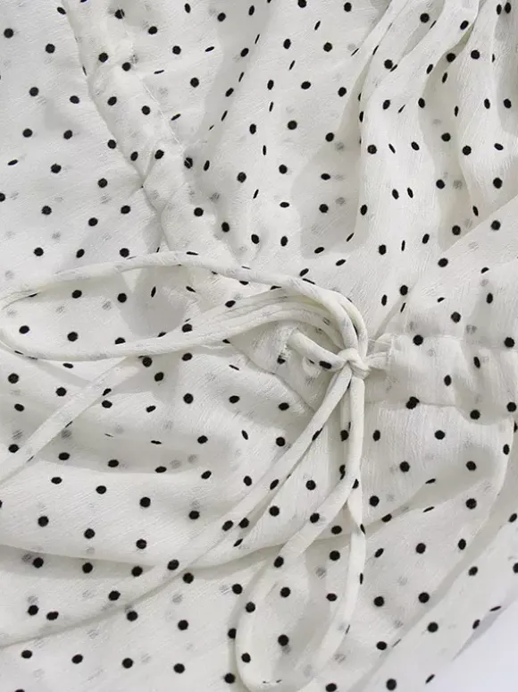 Blouse blanche pour femme col en V manches longues lacées et à volants.