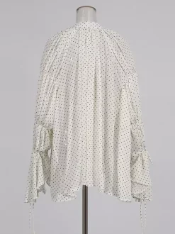 Blouse blanche pour femme col en V manches longues lacées et à volants.