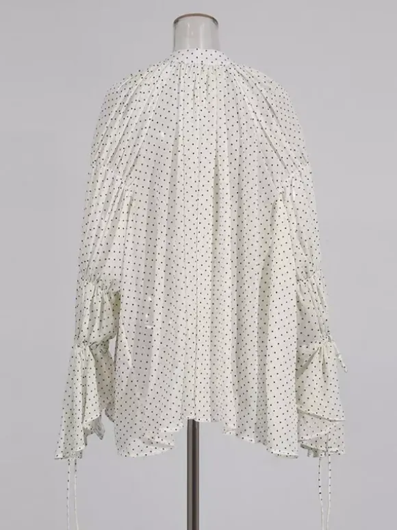 Blouse blanche pour femme col en V manches longues lacées et à volants.