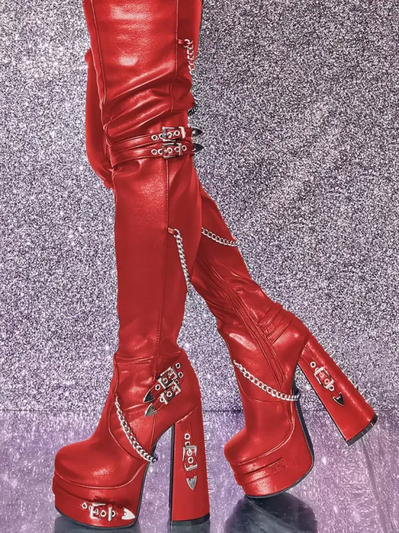 Bottes cuissardes noires gothiques pour femmes à plateforme et talons hauts avec détails métalliques.