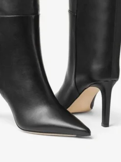 Bottes hautes noires à bout pointu avec détails en métal et talons hauts à tige droite