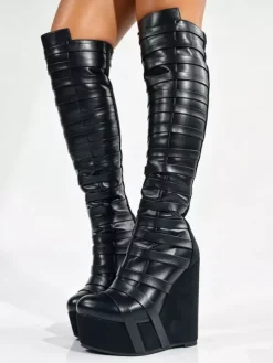 Bottes noires montantes à plateforme pour femmes à brides et fermeture éclair à talon compensé.
