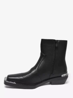 Bottines noires à bout carré et talon épais ornées de détails métalliques