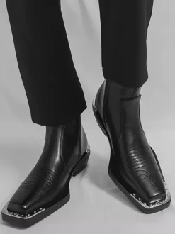 Bottines noires à bout carré et talon épais ornées de détails métalliques