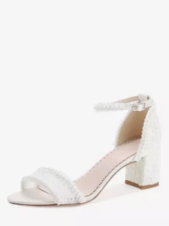 Chaussures de mariée ivoire à bout ouvert et talon compensé ornées de dentelle.