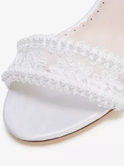 Chaussures de mariée ivoire à bout ouvert et talon compensé ornées de dentelle.
