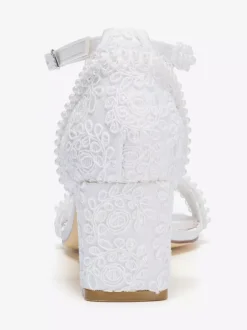 Chaussures de mariée ivoire à bout ouvert et talon compensé ornées de dentelle.