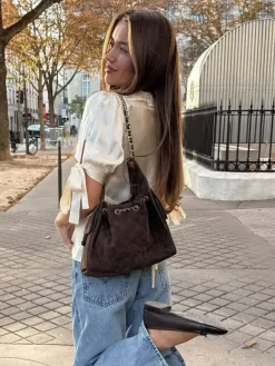 Chemisier en satin à col V bouffant et manches courtes bouffantes orné de dentelle avec ceinture à nouer dans le dos et coupe ajustée. Élégante chemise pour femme.