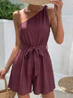 Combinaison-short d'été décontractée pour femme mauve asymétrique avec ceinture et tissu texturé à nouer à la taille.
