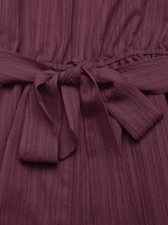 Combinaison-short d'été décontractée pour femme mauve asymétrique avec ceinture et tissu texturé à nouer à la taille.