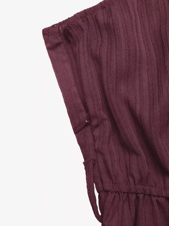 Combinaison-short d'été décontractée pour femme mauve asymétrique avec ceinture et tissu texturé à nouer à la taille.