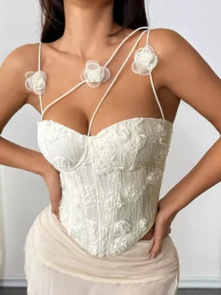 Corsets blancs sexy sans manches à bretelles et décolleté ajusté ornés de fleurs.