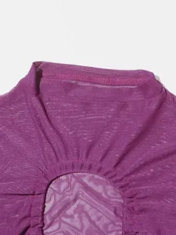 Crop top violet à col montant et manches longues à découpes apparentes.