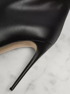 Cuissardes noires à bout pointu et talon aiguille sur les bottes au genou