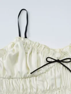 Ensemble deux pièces abricot chic plissé idéal pour les vacances avec bretelles et col à volants jupe sans manches à volants.