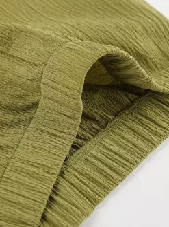 Ensemble deux pièces vert : haut sans manches dos nu et pantalon.