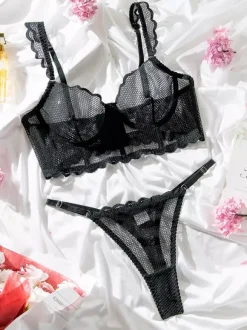 Ensemble soutien-gorge et culotte deux pièces noirs à volants en résille orné de motifs.