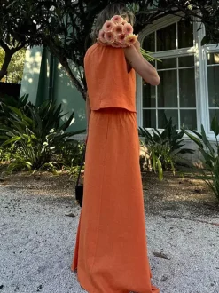 Ensemble deux pièces jupe et haut orange à boutons rétro style resort en lin col V sans manches.