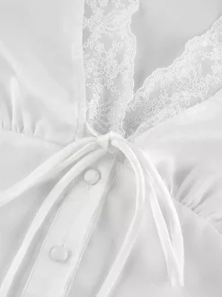 Ensemble 2 pièces pour femme 2026 : haut à col en V bordé de dentelle satinée et mini-jupe à nouer sur le devant