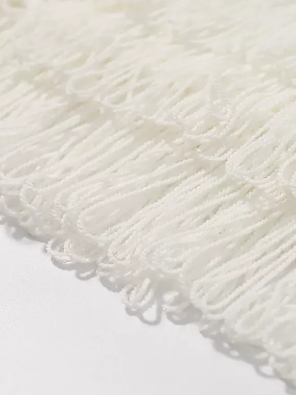 Ensemble 2 pièces pour femme : jupe blanche élégante à franges et revers manches longues.