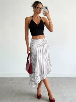 Jupe midi blanche à petits pois taille haute ourlet asymétrique à volants irréguliers en mousseline fluide.