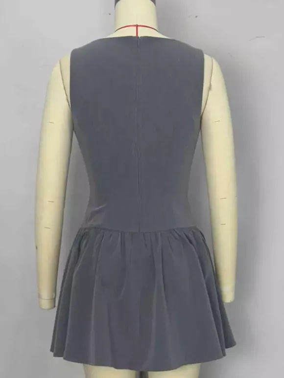 Mini-robe plissée sans manches et boutonnée sur le devant grise été 2026