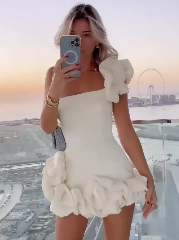 Robe blanche chic mini dos nu à volants et fermeture éclair sans manches et bustier idéale pour une soirée en amoureux.