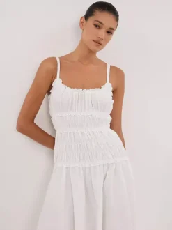 Robe blanche décontractée à bretelles plissées et sans manches pour une soirée en amoureux