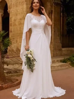 Robe de mariée bohème en dentelle col bijou manches longues et traîne en mousseline de soie.