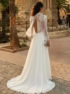Robe de mariée deux pièces en dentelle et mousseline col rond coupe trapèze avec traîne boutons et manches longues.