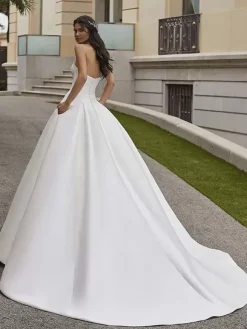 Robe de mariée princesse en satin bustier boutonné sur dos à grande traîne