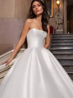 Robe de mariée princesse en satin bustier boutonné sur dos à grande traîne