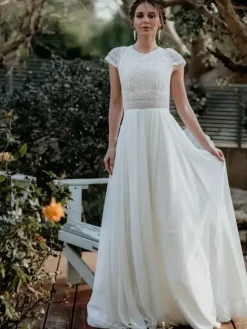 Robe de mariée simple en mousseline de soie col bijou manches courtes découpes courtes 30 cm