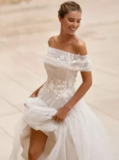 Robe de mariée simple en tulle bustier manches courtes ornée d'appliqués coupe trapèze