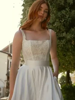 Robe de mariée vintage deux pièces courte en satin et dentelle coupe trapèze sans manches longue.