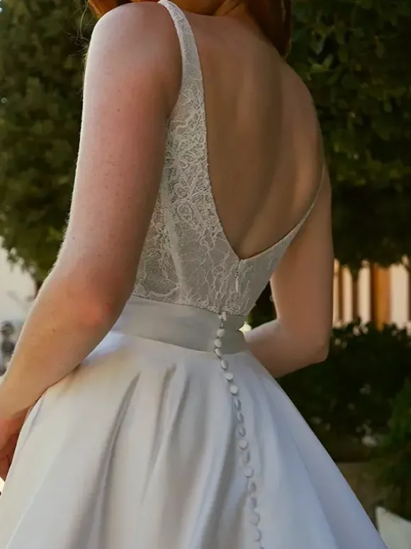 Robe de mariée vintage deux pièces courte en satin et dentelle coupe trapèze sans manches longue.