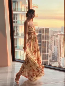 Robe de soirée longue à bretelles spaghetti et dos nu imprimé floral style bohème idéale pour l'été et la plage.