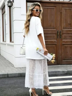 Robe longue blanche élégante en dentelle à manches courtes et col rond idéale pour une soirée romantique.