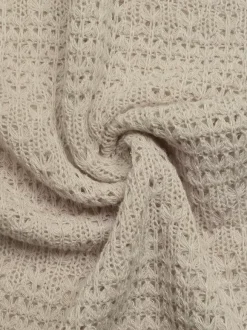 Robe longue bustier beige en maille crochet pour femme ornée d'étoiles de mer avec découpe en forme de goutte et fente latérale. Robe d'été idéale pour la plage.