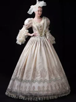 Robe longue de bal champagne style victorien rococo ornée de dentelle manches évasées et imprimé floral.