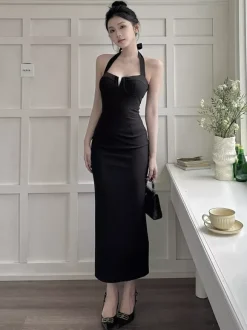 Robe longue noire élégante dos nu à lacets sans manches et décolleté licou idéale pour une soirée en amoureux.