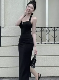 Robe longue noire élégante dos nu à lacets sans manches et décolleté licou idéale pour une soirée en amoureux.