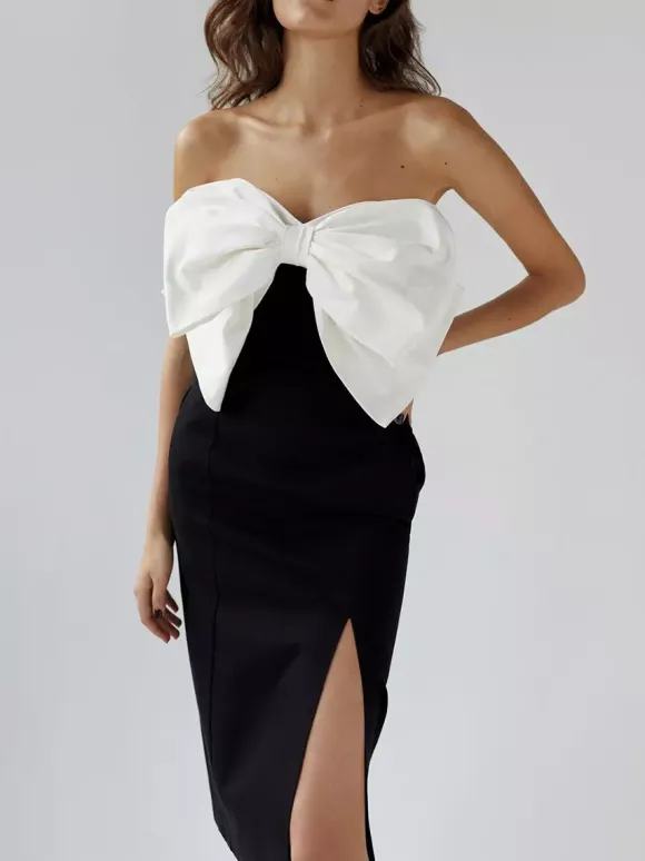 Robe noire chic à bretelles dos nu et sans manches ornée de n艙uds idéale pour une soirée romantique.