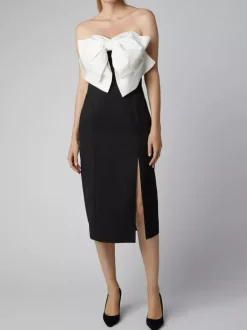 Robe noire chic à bretelles dos nu et sans manches ornée de n艙uds idéale pour une soirée romantique.