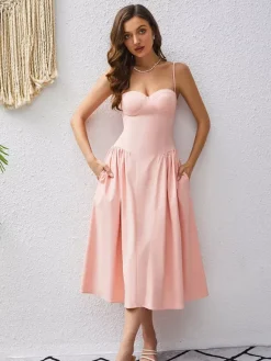 Robe rose élégante mi-longue sans manches à bretelles et col montant idéale pour une soirée en amoureux.
