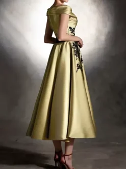 Robe de bal en satin décolleté travaillé manches courtes ornée d'appliqués