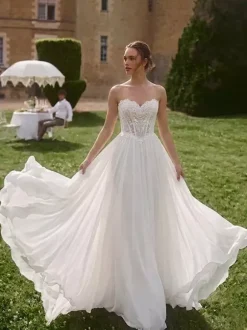 Robe de mariée bohème deux pièces décolleté en dentelle coupe trapèze avec traîne boutons fonctionnels manches longues.
