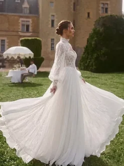 Robe de mariée bohème deux pièces décolleté en dentelle coupe trapèze avec traîne boutons fonctionnels manches longues.