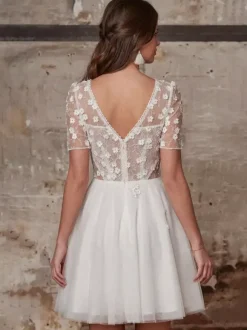Robe de mariée courte en dentelle pour mariage civil col en V manches courtes coupe trapèze.