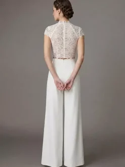Robe de mariée deux pièces en crêpe stretch décolleté travaillé longueur au sol fermeture éclair manches courtes.